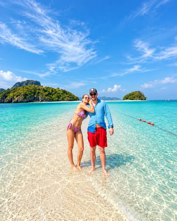 Couple standing on the Tup Island sandbar in shallow, clear water