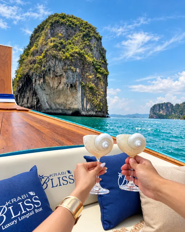 Two guests toasting on the Krabi Bliss boat, with a limestone island ahead