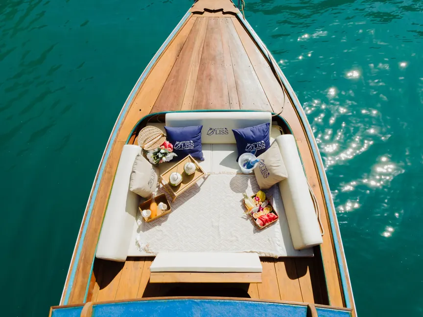 Fruit platter, fresh coconuts and juice set out on the bow lounge of the Krabi Bliss longtail boat